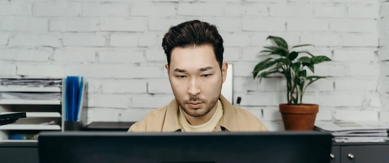 An office worker concentrating on tasks at his modern desk in a contemporary setting.